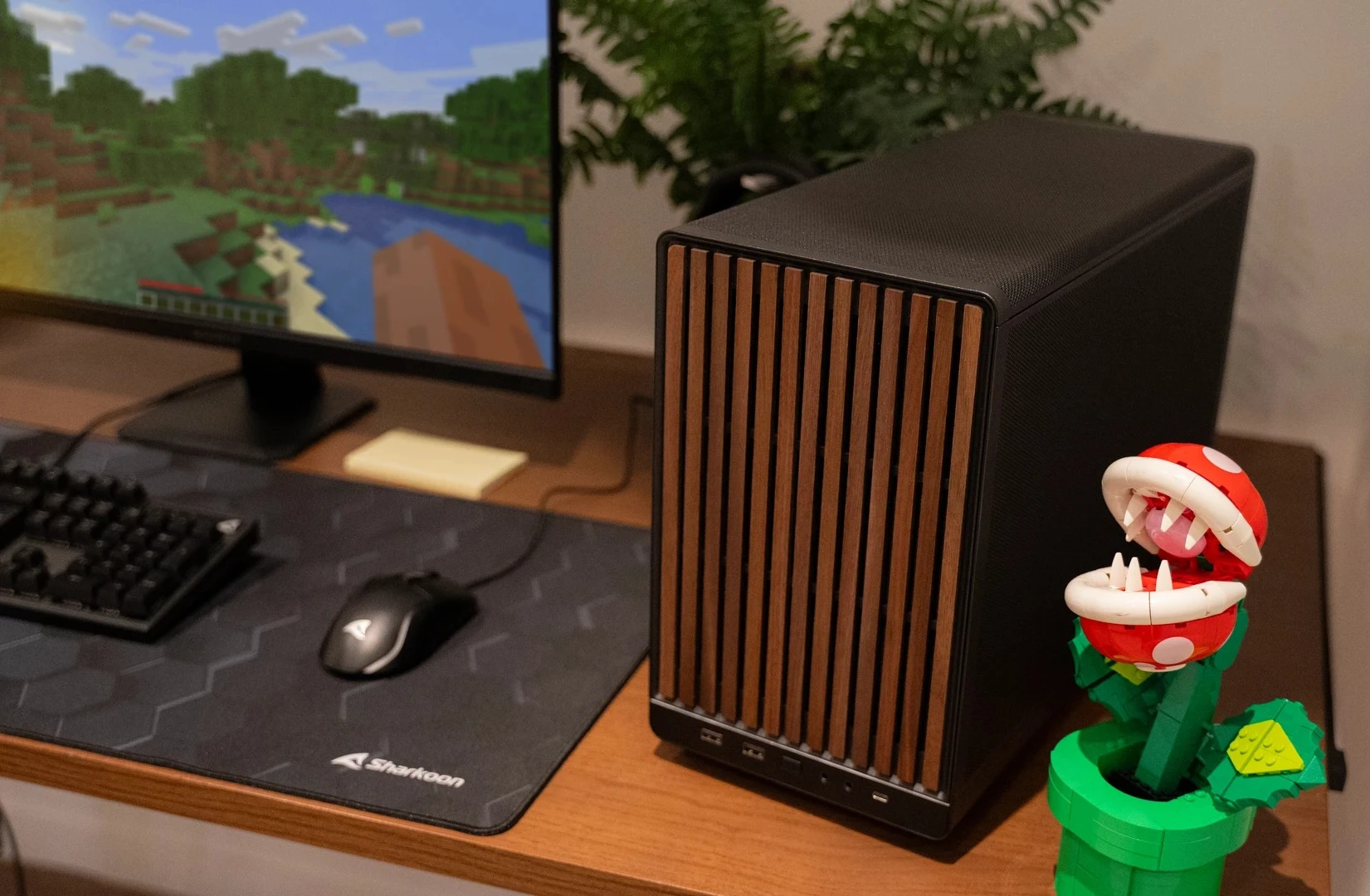 Compacte zwarte pc met houten frontpaneel op bureau